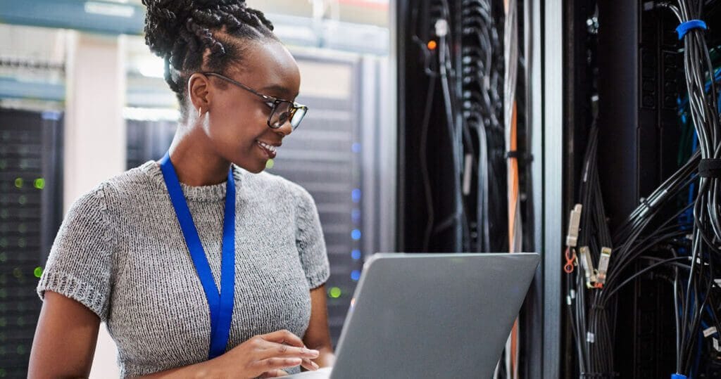 Woman working in a network/IT closet.