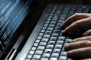 IT staff writing code on a laptop.