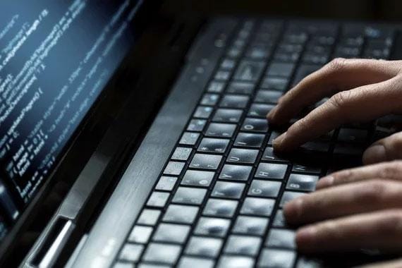 IT staff writing code on a laptop.