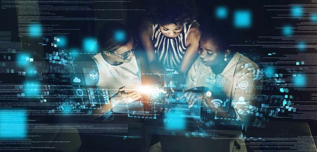 Three business women reviewing lines of code.