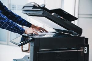 Employee making a photo copy in a printer.