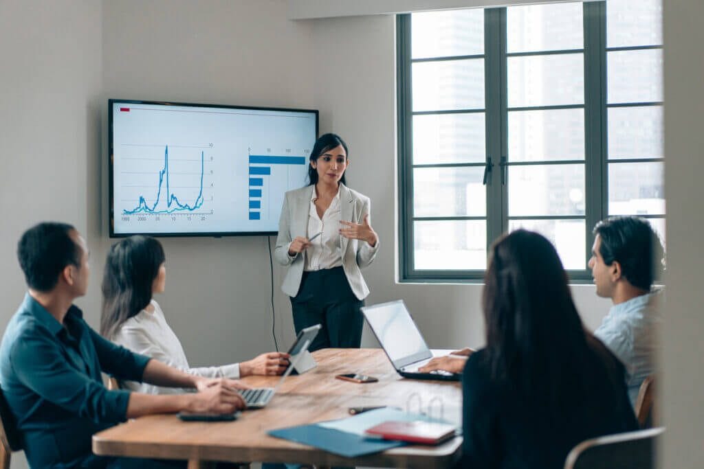 Woman giving presentation in a small conference room.