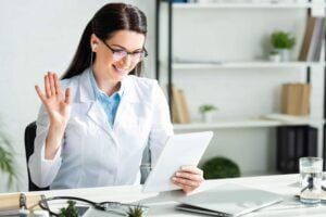 A woman on a telehealth video call via a tablet.