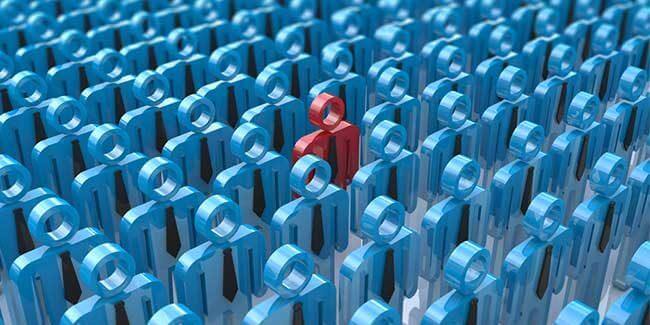 Human figures standing together with one stand out red one in the middle.