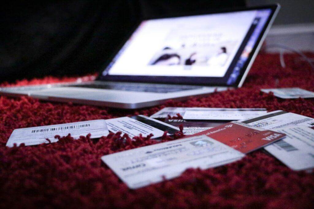 Credit cards piled up next to a computer.