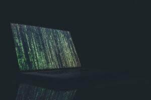 Lines of code streaming down on a laptop computer.