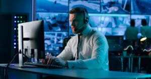 IT staff with headset working with clients over the phone on cybersecurity issues.